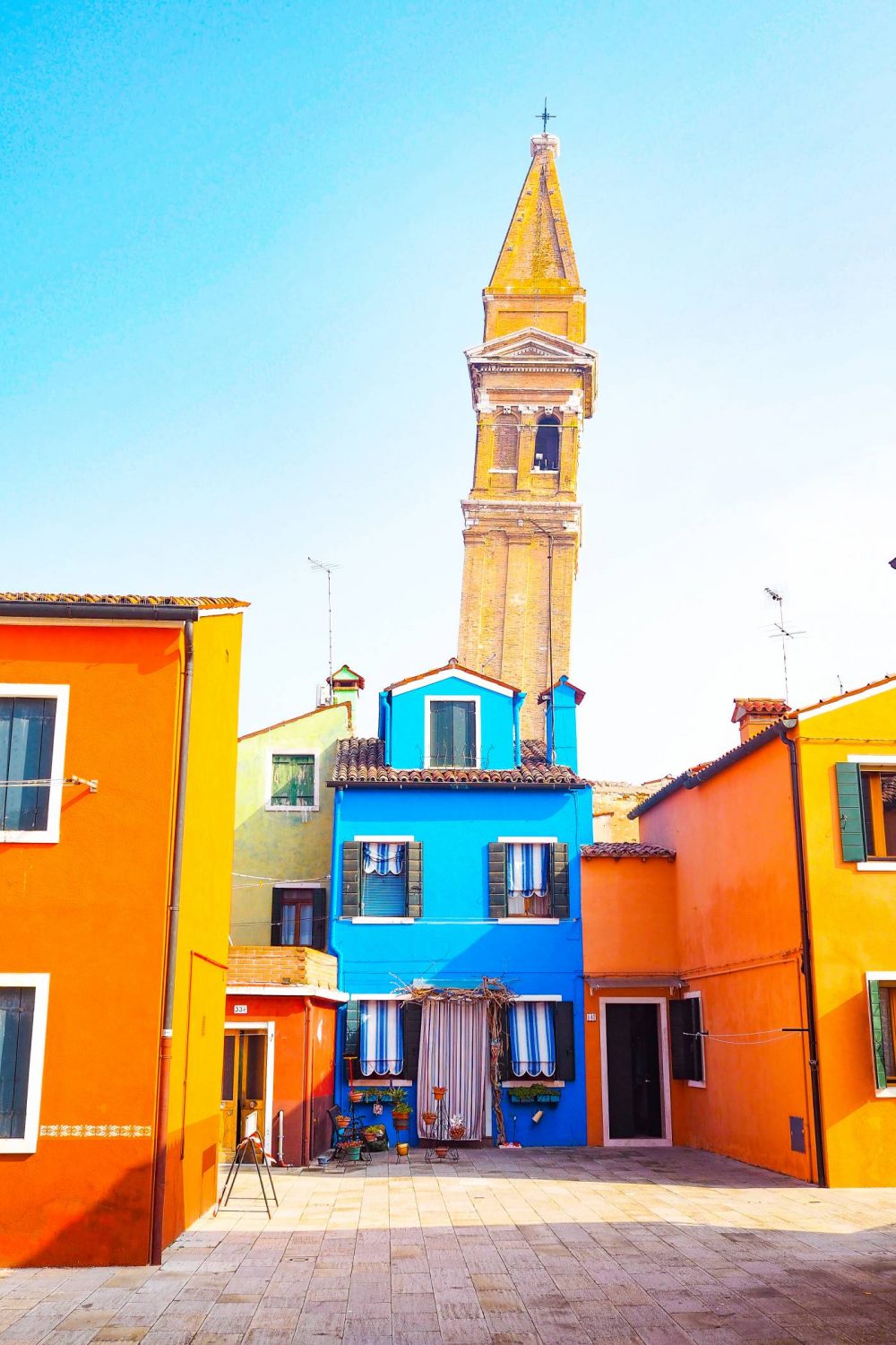 Burano Clock tower behind a bright blue house
